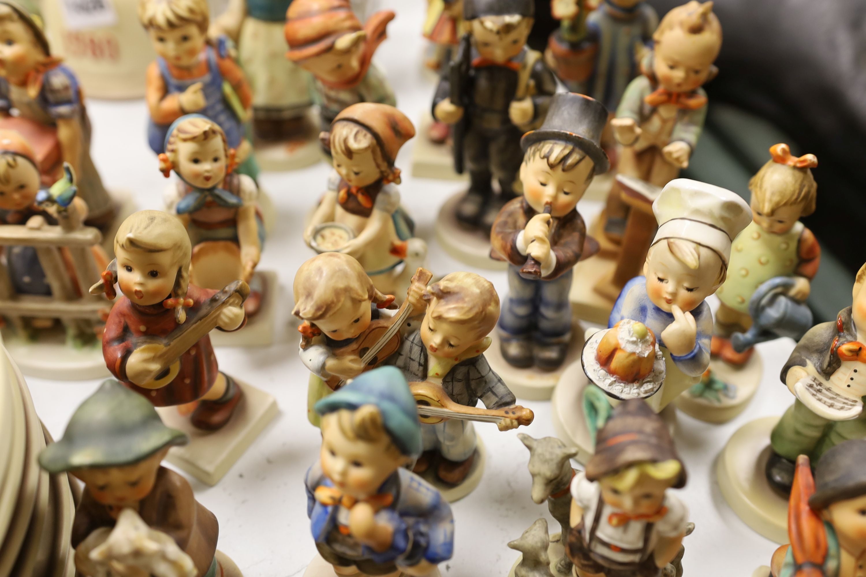 A large collection of Hummel pottery figures, approximately 70 including skier and two similar plaques, some with boxes.